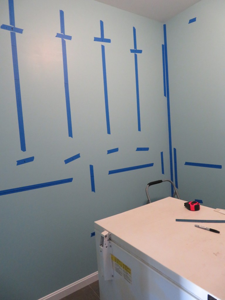 Marking the walls with the locations of the studs and shelf levels.